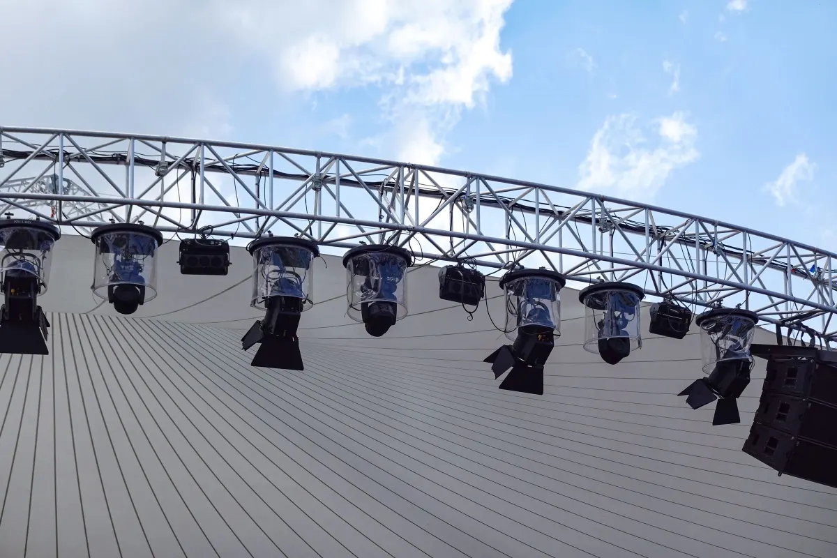Estructura de truss curvo con luces robotizadas y parlantes sobre un escenario